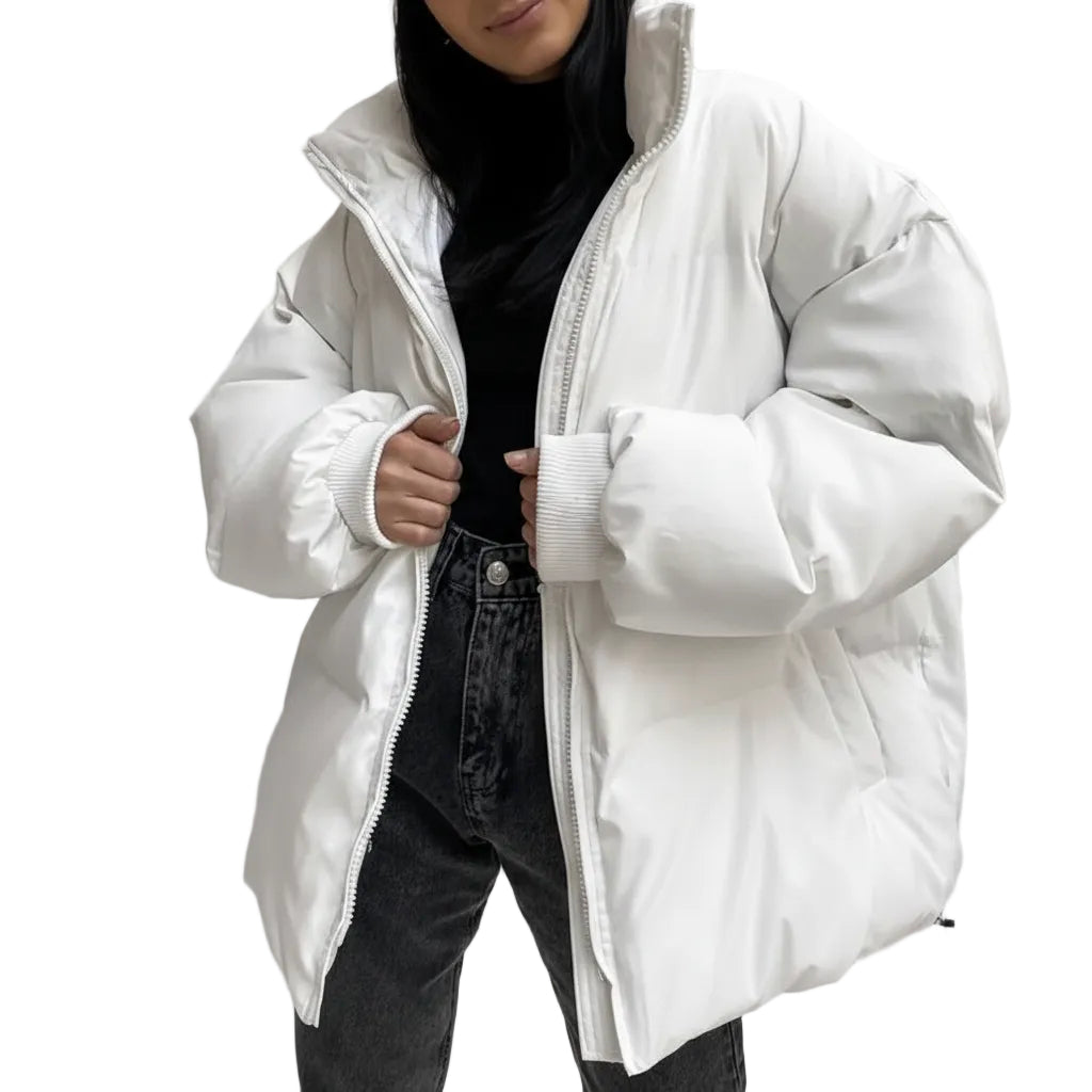 Person wearing a white puffer jacket over a black outfit against a plain background