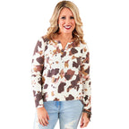 Woman wearing a patterned blouse and jeans indoors