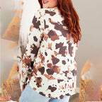 Person wearing a cow print top with a blurred background