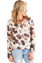 Woman wearing a patterned blouse and jeans on a white background