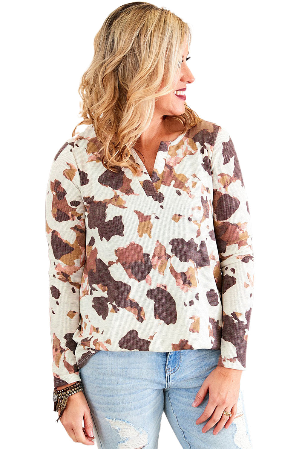 Woman wearing a patterned blouse and jeans on a white background