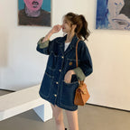 Woman wearing a denim jacket and holding a brown handbag in an art gallery.