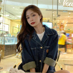 Woman wearing a denim jacket in a shopping mall setting