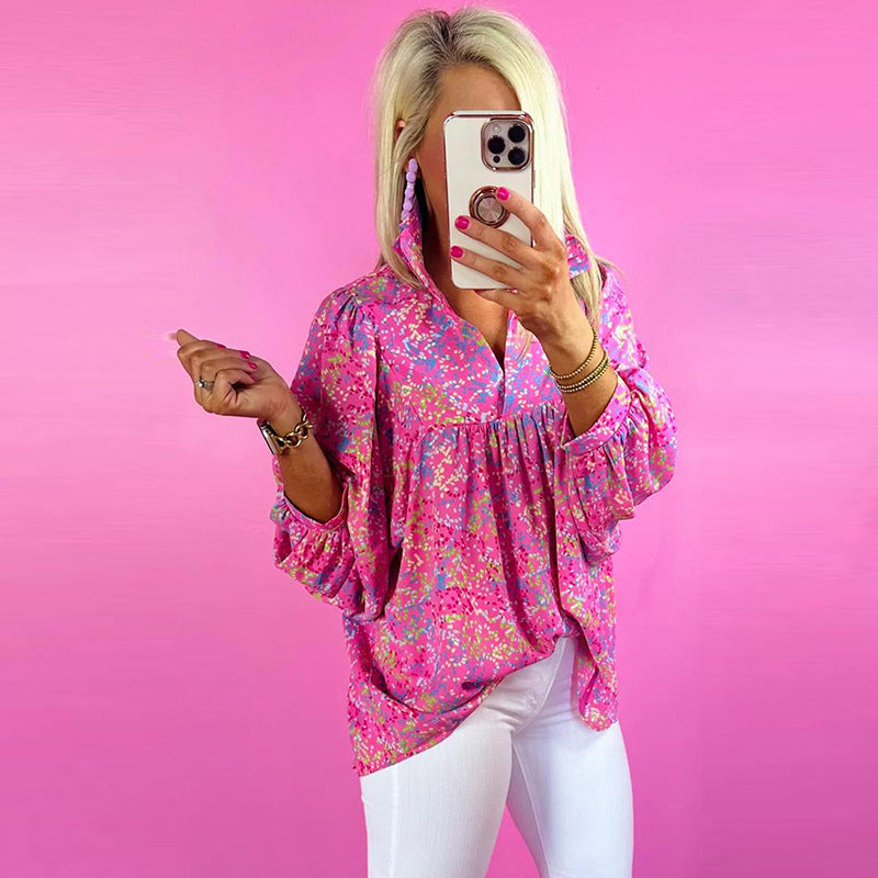 Person wearing a pink floral blouse against a pink background