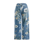 Floral-patterned jeans on a light gray background