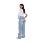 Person wearing light blue jeans and a white top on a plain background