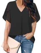 Woman wearing a black top and blue jeans, holding a beige clutch.