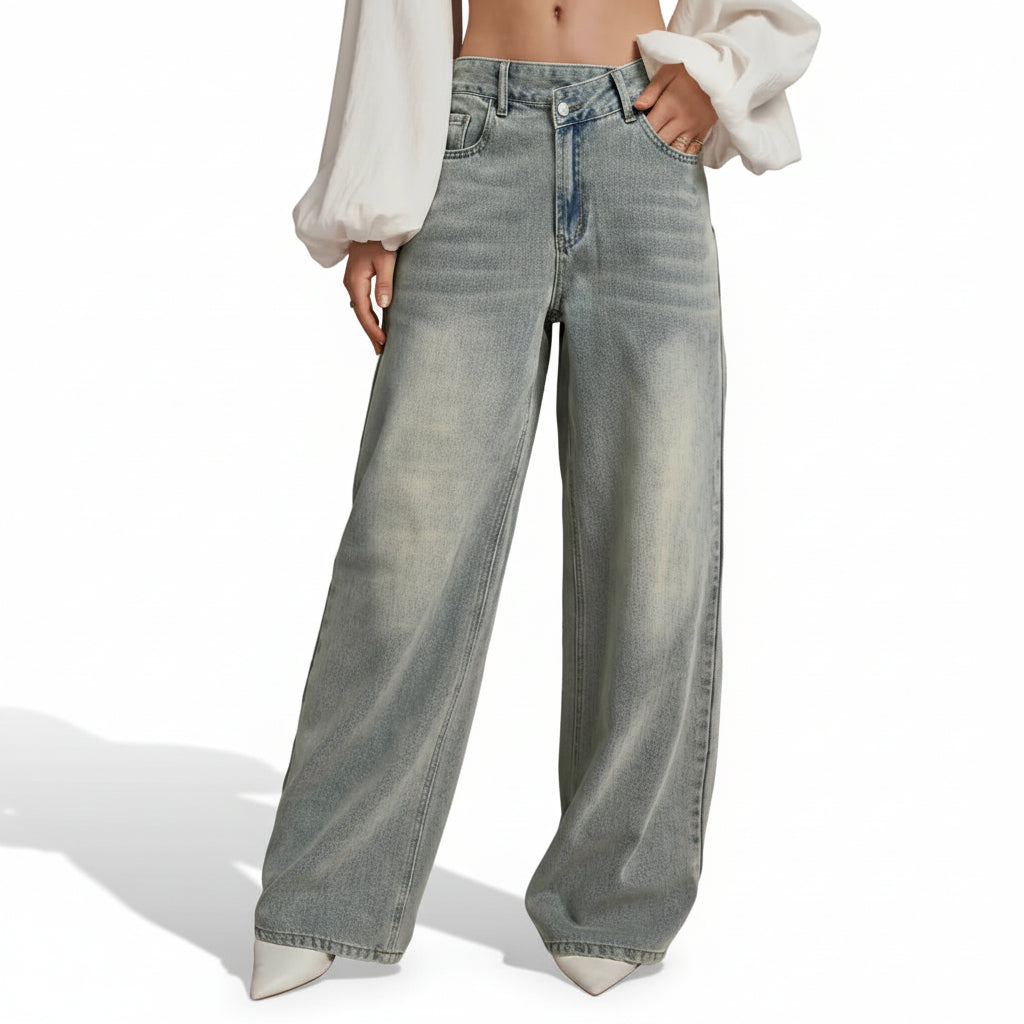 Person wearing light blue jeans on a beige background