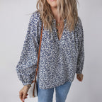 Woman wearing a floral blouse and jeans with a neutral background