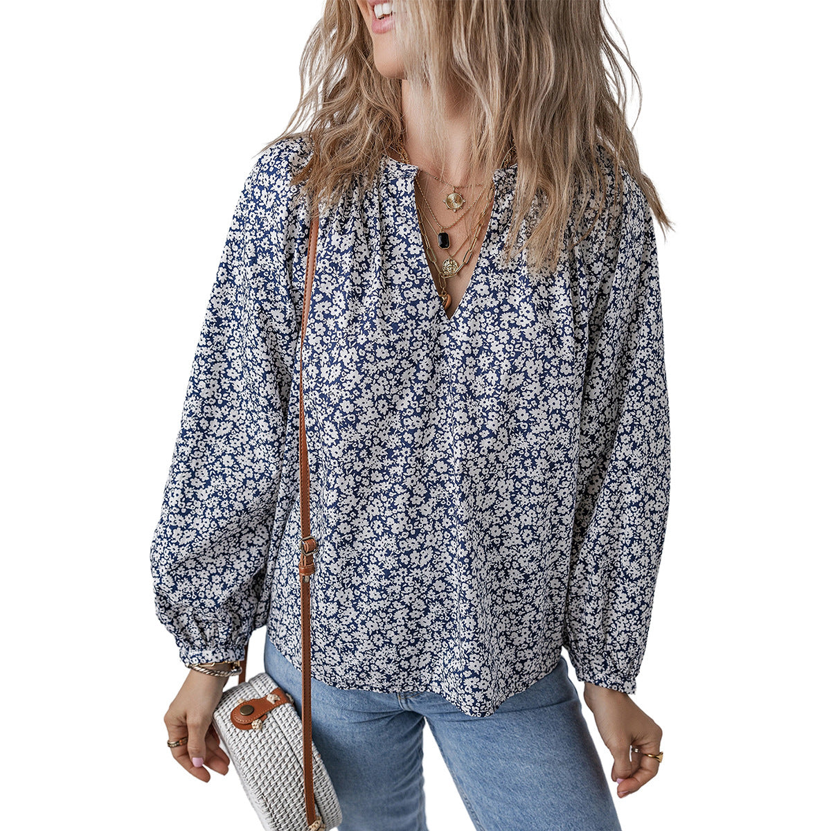 Woman wearing a floral blouse and holding a handbag on a white background