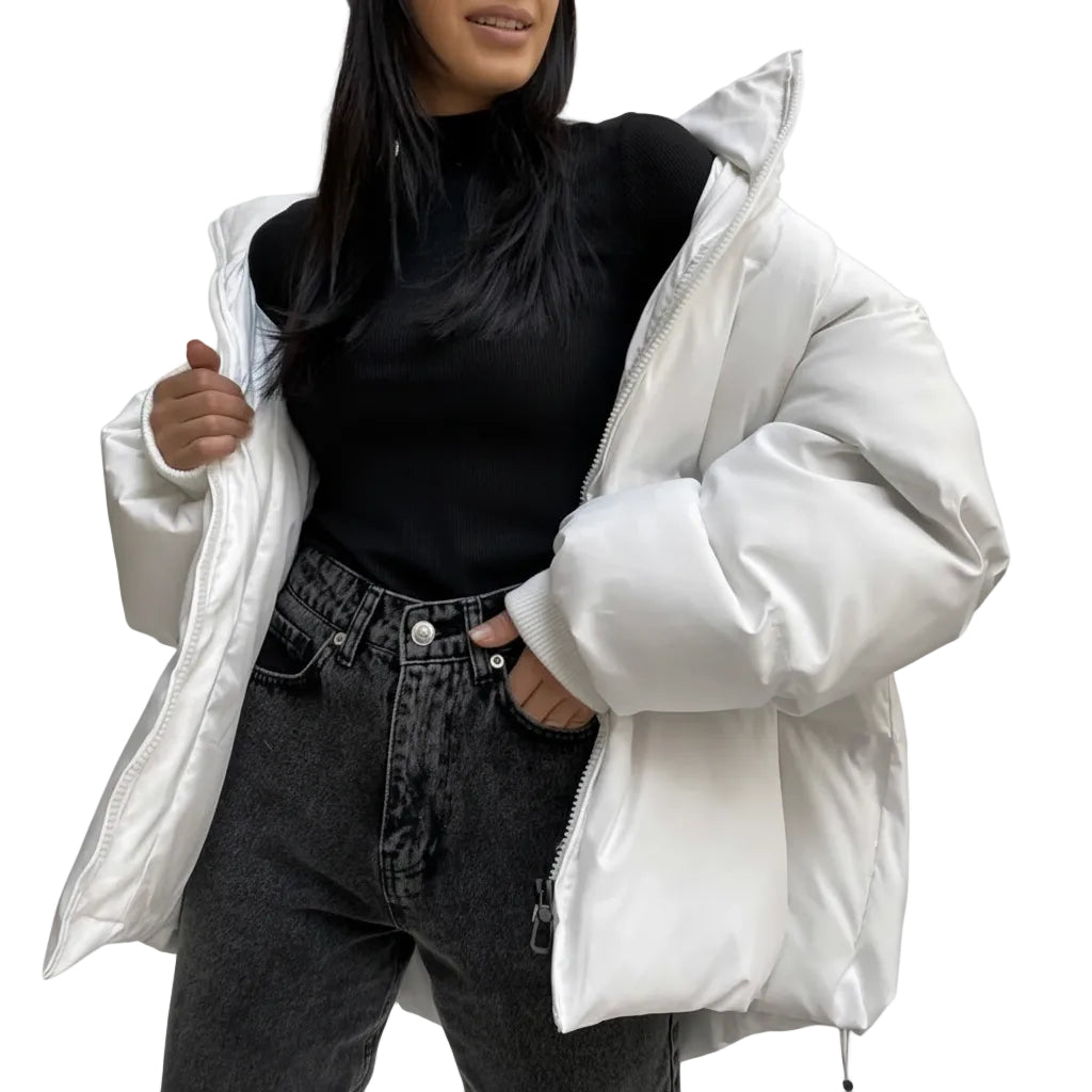 Person wearing a white puffer jacket over a black top and gray jeans on a plain background