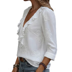 White blouse with floral embroidery worn by a person, blurred background