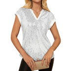 Woman wearing a white sequin top with a blurred background