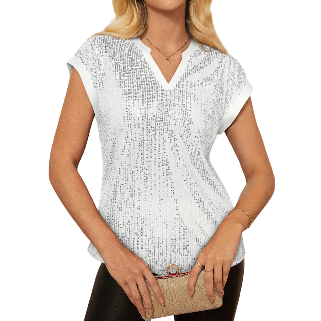 Woman wearing a white sequin top with a blurred background