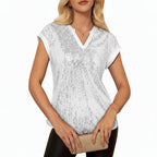 Woman wearing a white sequin top in an elegant indoor setting