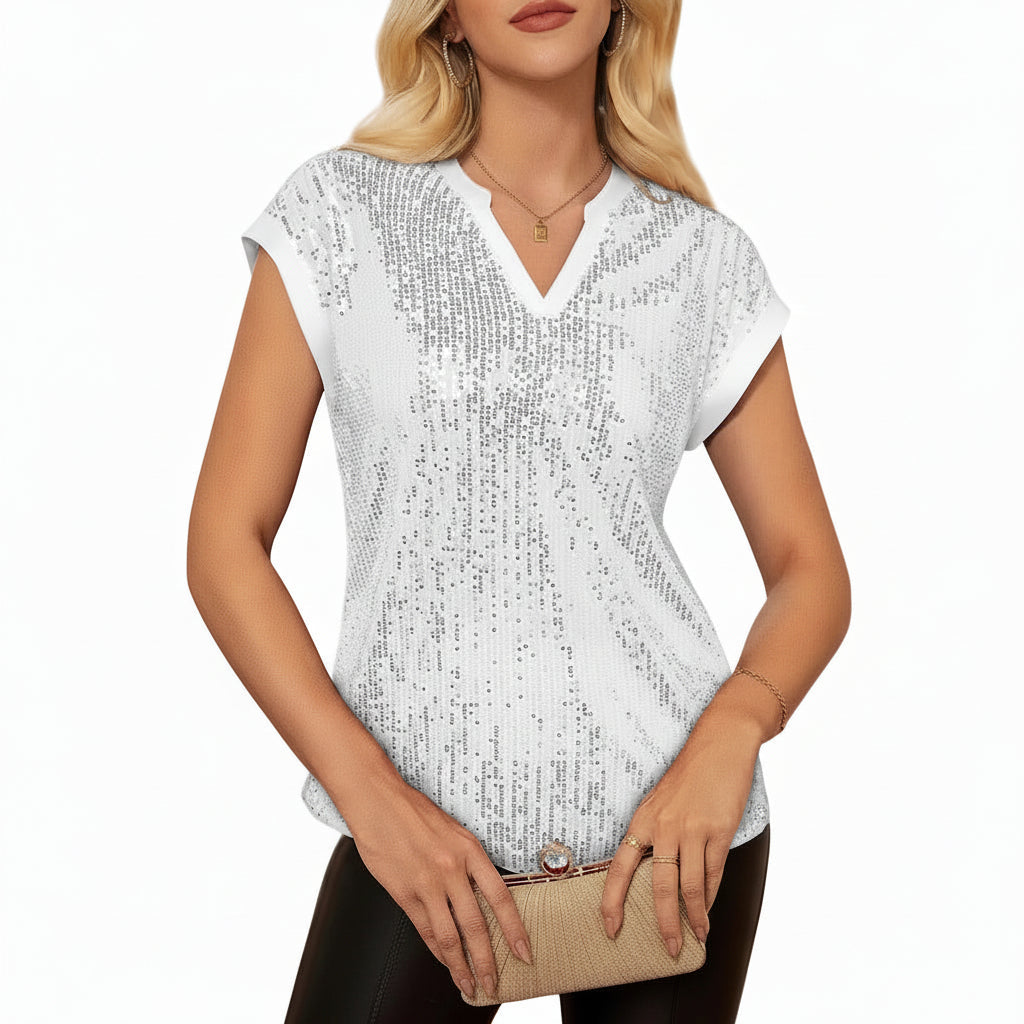 Woman wearing a white sequin top in an elegant indoor setting