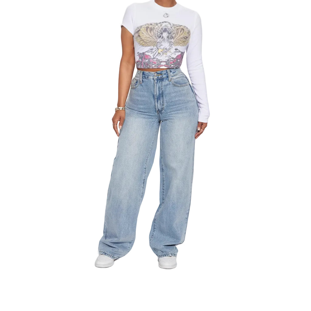 Person wearing a white long-sleeve crop top with a graphic design and light blue jeans on a plain background