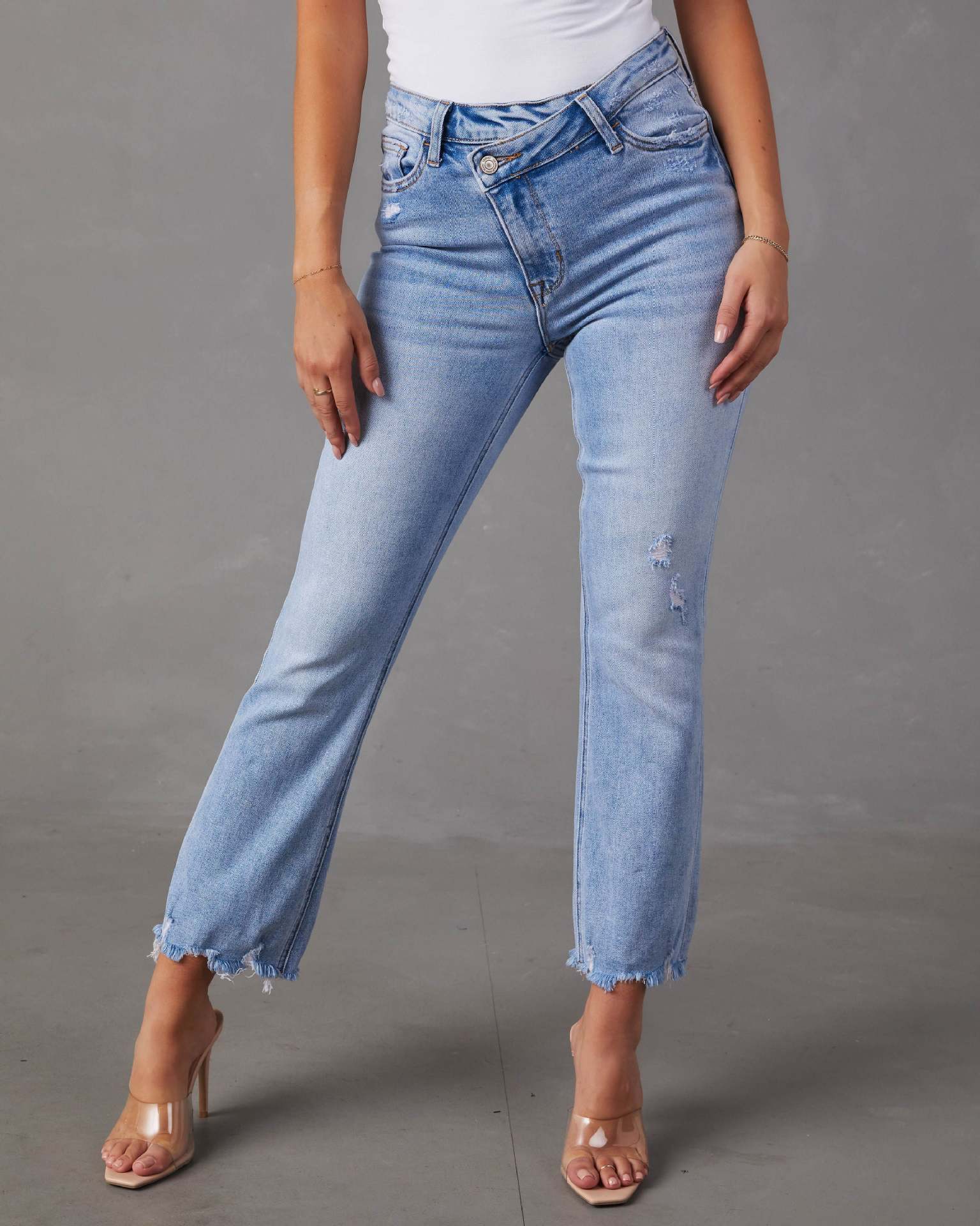 Light blue jeans worn by a person on a gray background