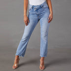 Light blue jeans worn by a person on a gray background